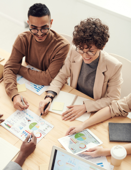 A team of professionals gathered at a table, actively collaborating and exchanging thoughts on their work.